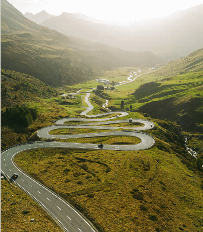 A long windy road in the middle of mountains.
